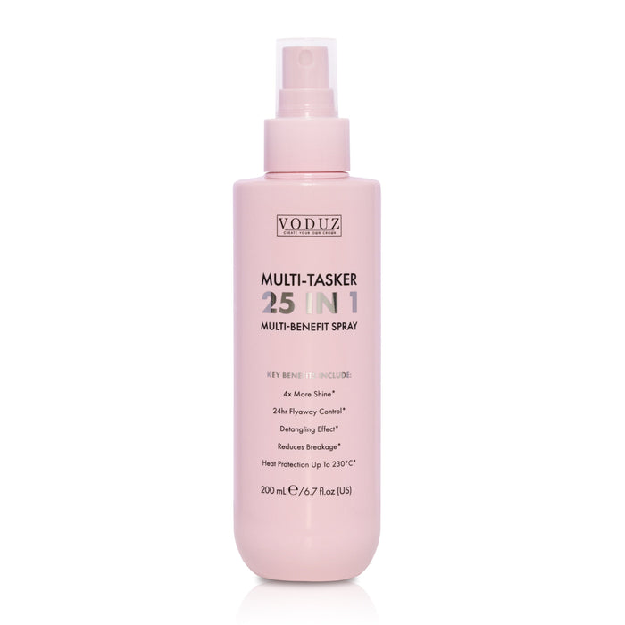 A bottle of VODUZ Multi-Tasker 25 In 1 Multi-Benefit Spray in a soft pastel pink color, shown on a clean white background with a subtle reflection.