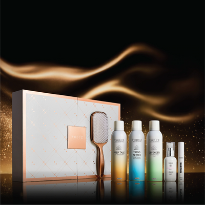 Voduz Ultimate Vault hair care product set with a paddle brush and packaging on a dark background